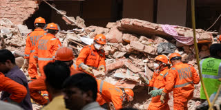 National Disaster Response Force (NDRF) personnel clear rubble during rescue operations after a multi-storey building housing a PG collapsed in Satya Niketan, New Delhi, on Monday.