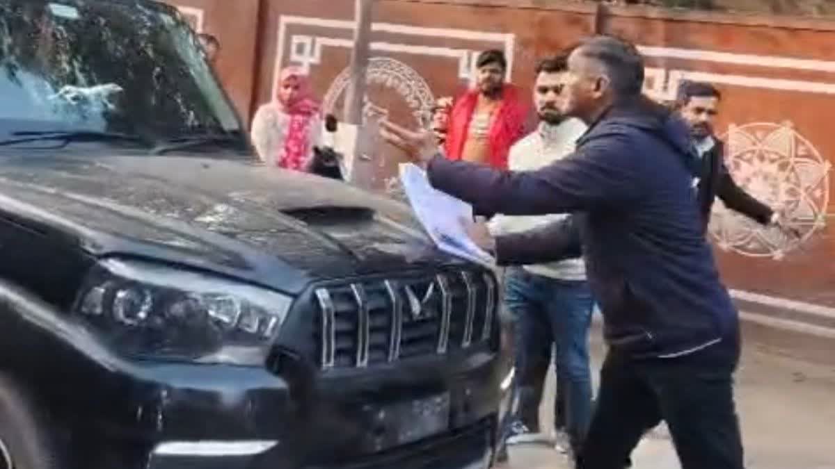 गाड़ी को रोकने की कोशिश करते पुलिसकर्मी