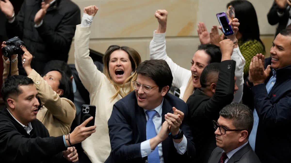 FILE - Miguel Uribe Turbay, center in blue tie, a Colombian senator and presidential candidate for the right-wing Centro Democrático party, celebrates after voting against a labor reform referendum proposed by the government, in Bogota, Colombia, May 14, 2025.