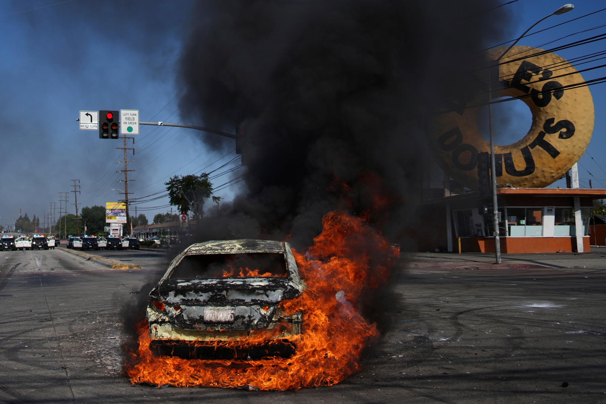 A car burns during a protest in Compton, Calif., Saturday, June 7, 2025, after federal immigration authorities conducted operations.