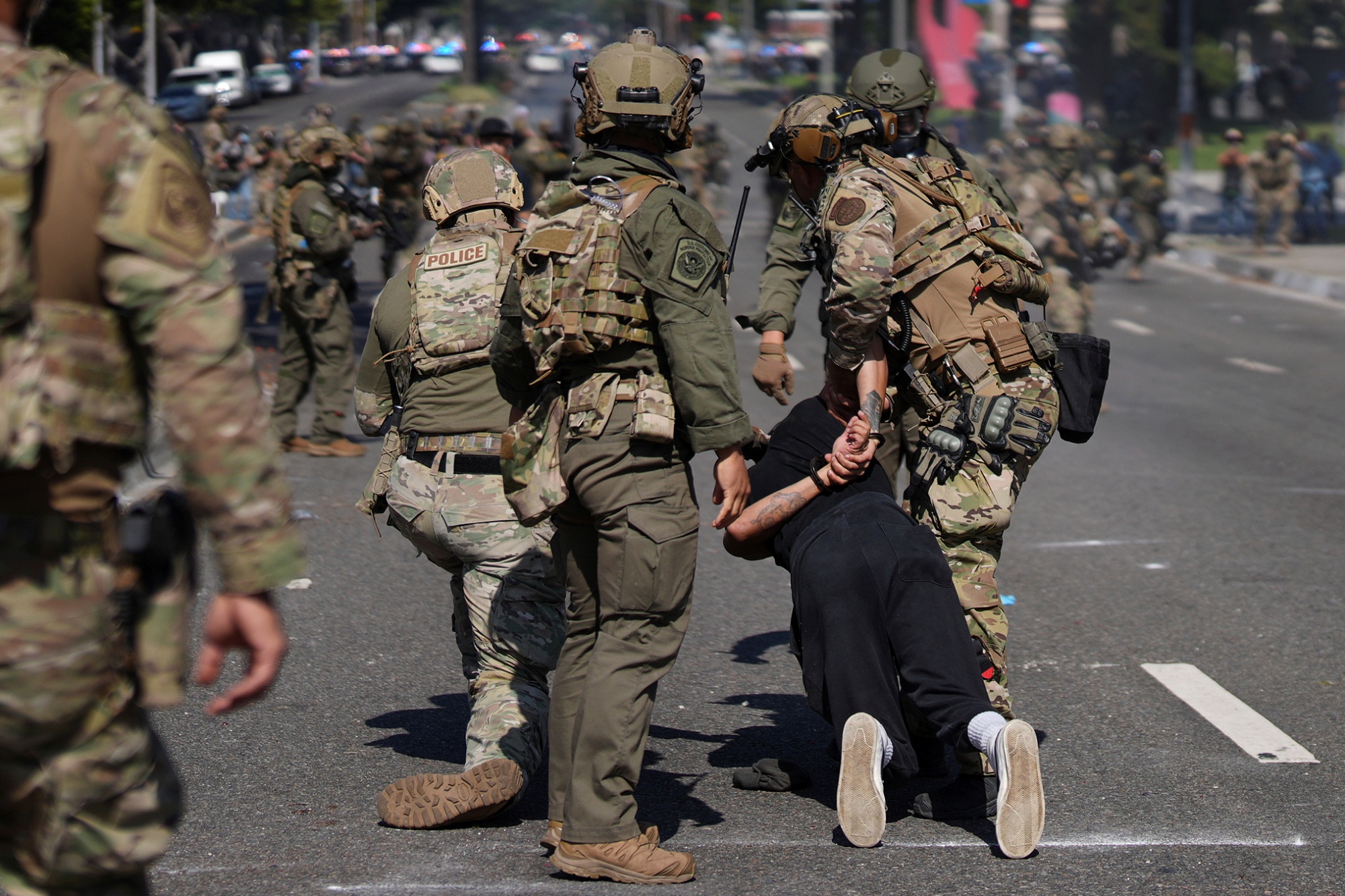 Police detain a man during a protest in the Paramount section of Los Angeles, Saturday, June 7, 2025, after federal immigration authorities conducted operations.