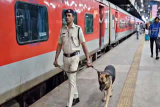 A policeman along with a sniffer dog outside Dehradun Express in Ratlam
