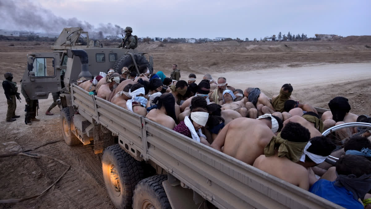 In Rare Ruling, Israeli Supreme Court Says Israel Deprives Palestinian Prisoners Of Food FILE - Israeli soldiers stand by a truck packed with bound and blindfolded Palestinian detainees, in Gaza, Dec. 8, 2023.