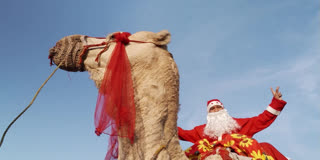 Men dressed as Santa Claus ride camels along streets in Islamabad.