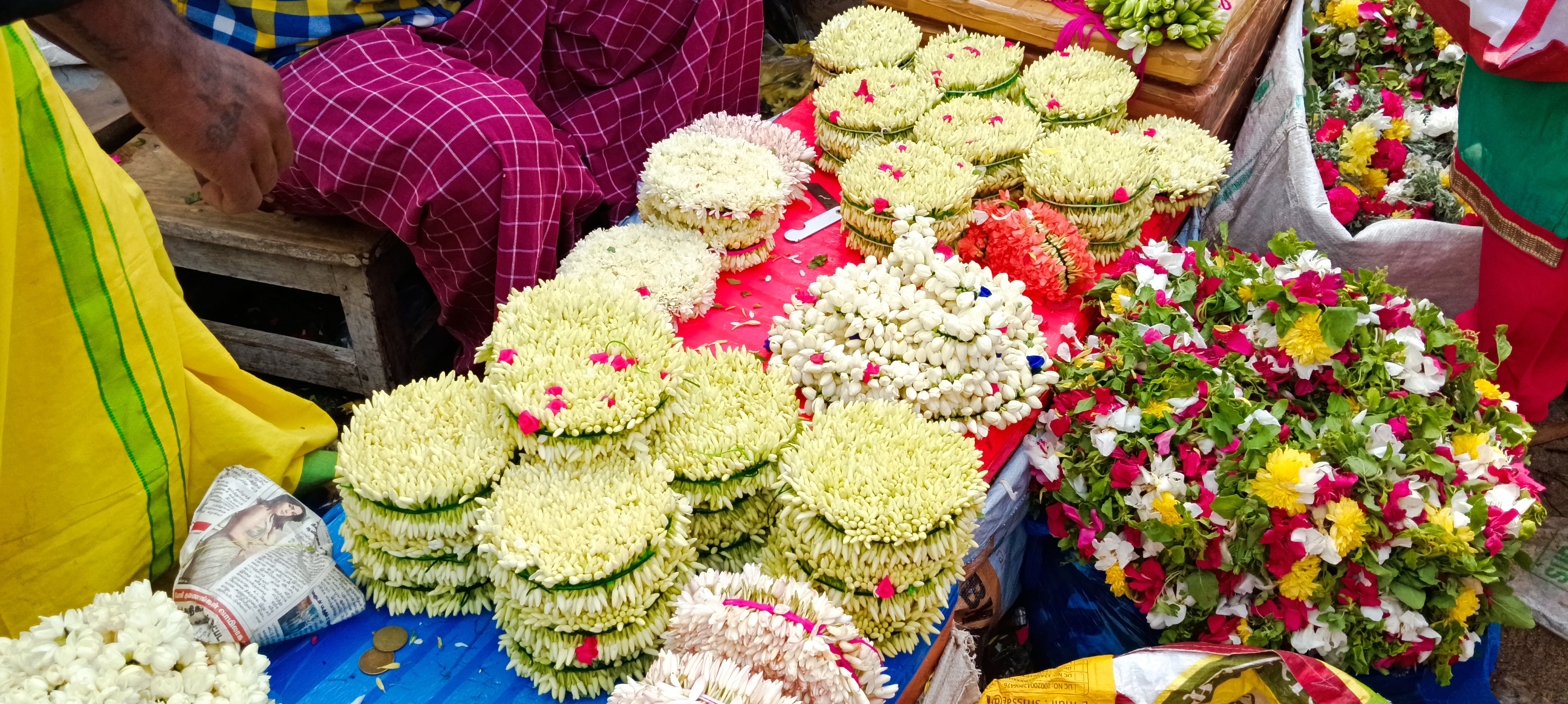 மதுரை மலர் சந்தையில் விற்பனைக்காக அடுக்கி வைக்கப்பட்டிருக்கும் பூப்பந்துகள்