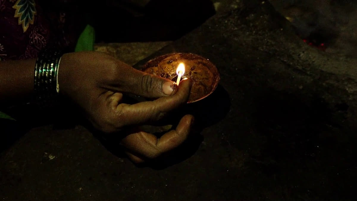 A woman lighting an earthen lamp in Khanapur