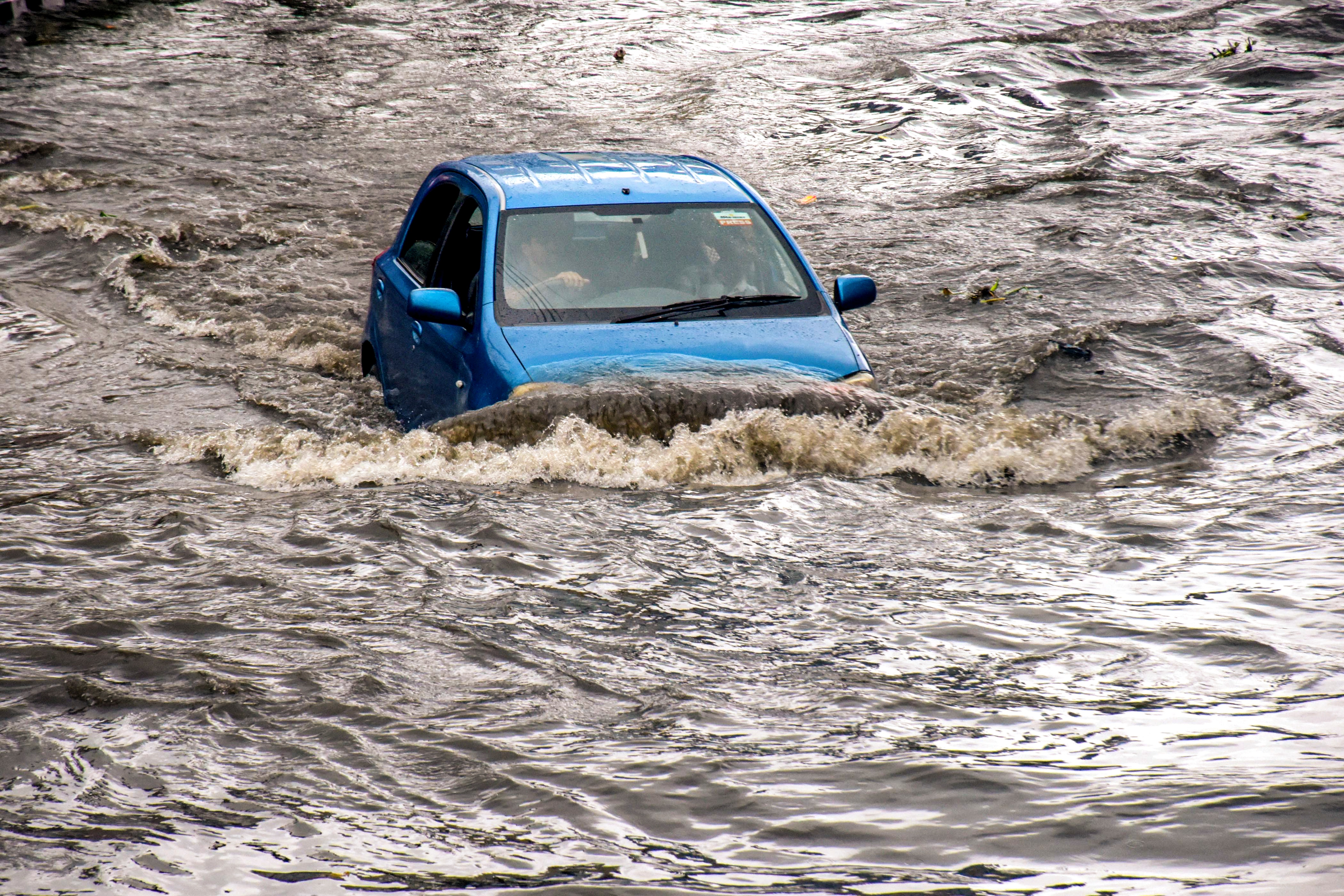A vehicle wades through a severely waterlogged road amid rainfall, in Haridwar, on Thursday.