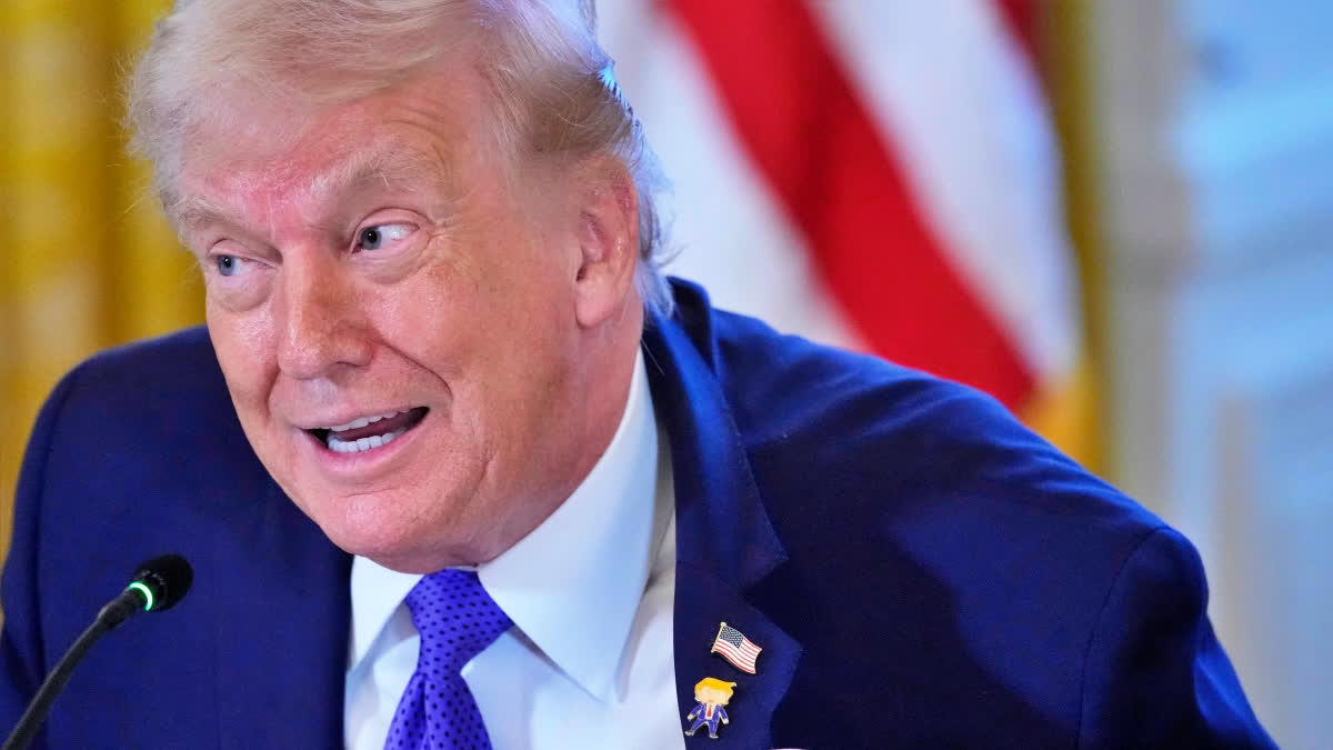 President Donald Trump wears a gift, which he calls a "Happy Trump" pin, during a meeting with oil executives in the East Room of the White House, Friday, Jan. 9, 2026, in Washington
