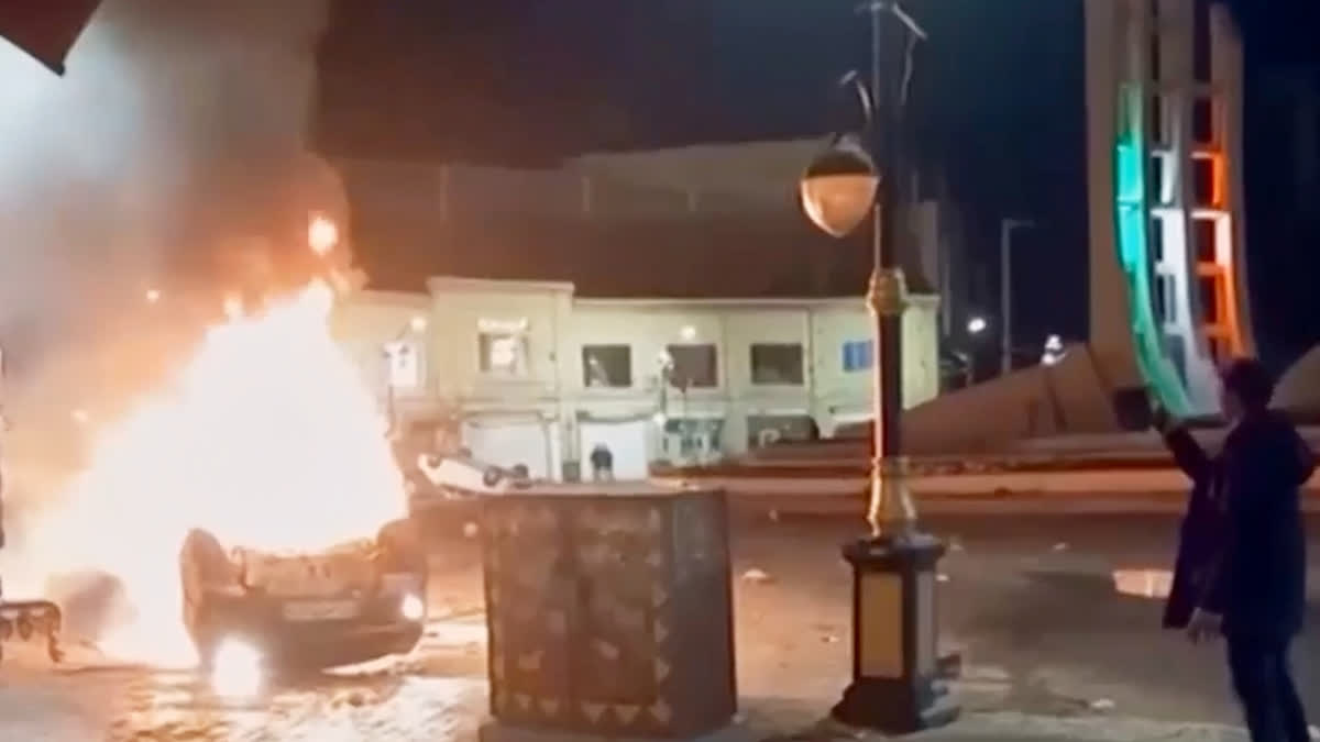 'US Supports Brave People Of Iran', Says Rubio As Protests Near 2-Week Mark Amid Intensified Crackdown This frame grab from a video released Friday, Jan. 9, 2026, by Iranian state television shows a man holding a device to document burning vehicles during a night of mass protests in Zanjan, Iran.