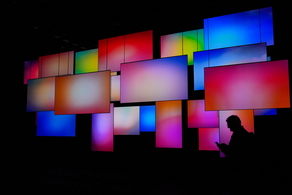A Person walks past a wallpaper TV display at the LG booth during the CES tech show Wednesday, Jan. 7, 2026, in Las Vegas