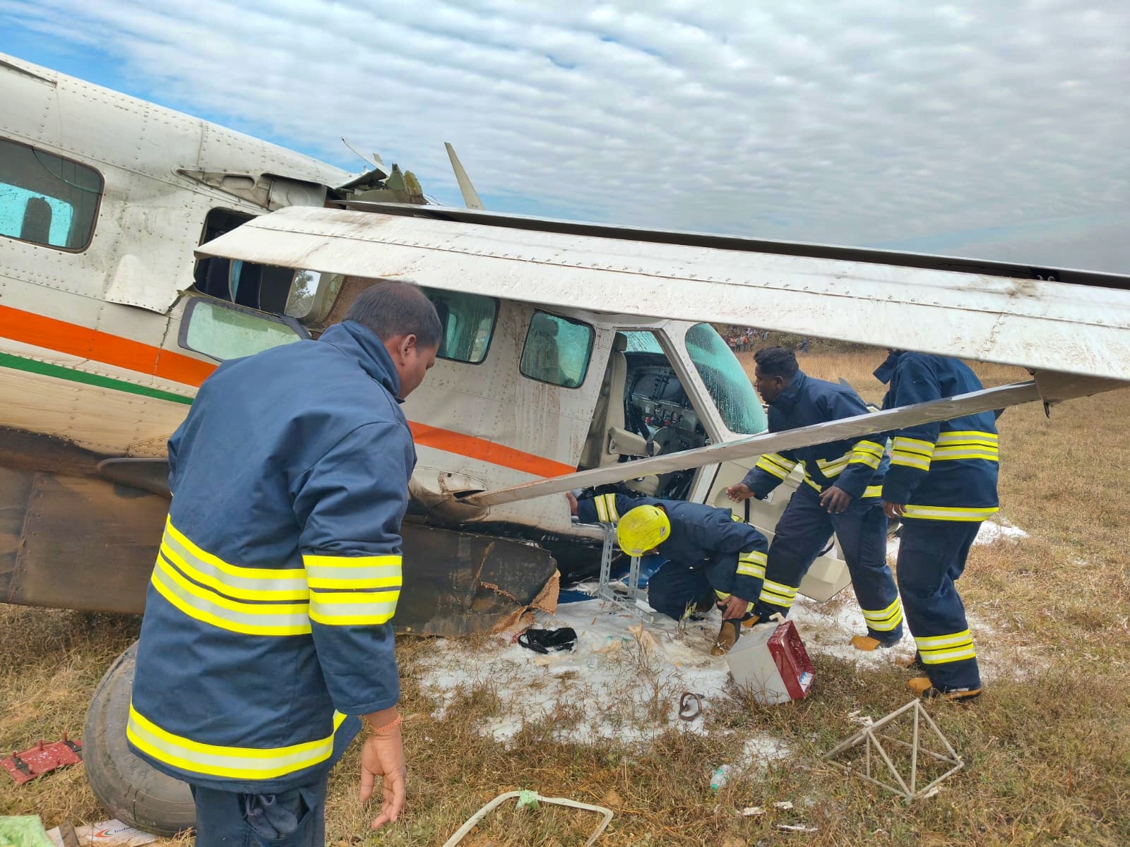 Fire service personnel try to control oil leakage from the plane after the plane crash.