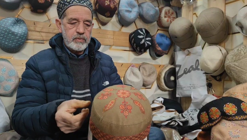 Cap artist Riaz Ahmad works on a Sozni cap inside his shop in Srinagar