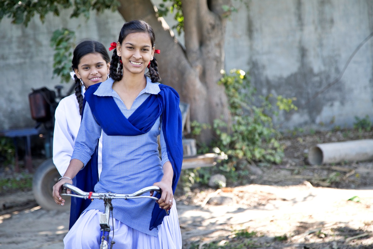 Girls in a village on a bicycle