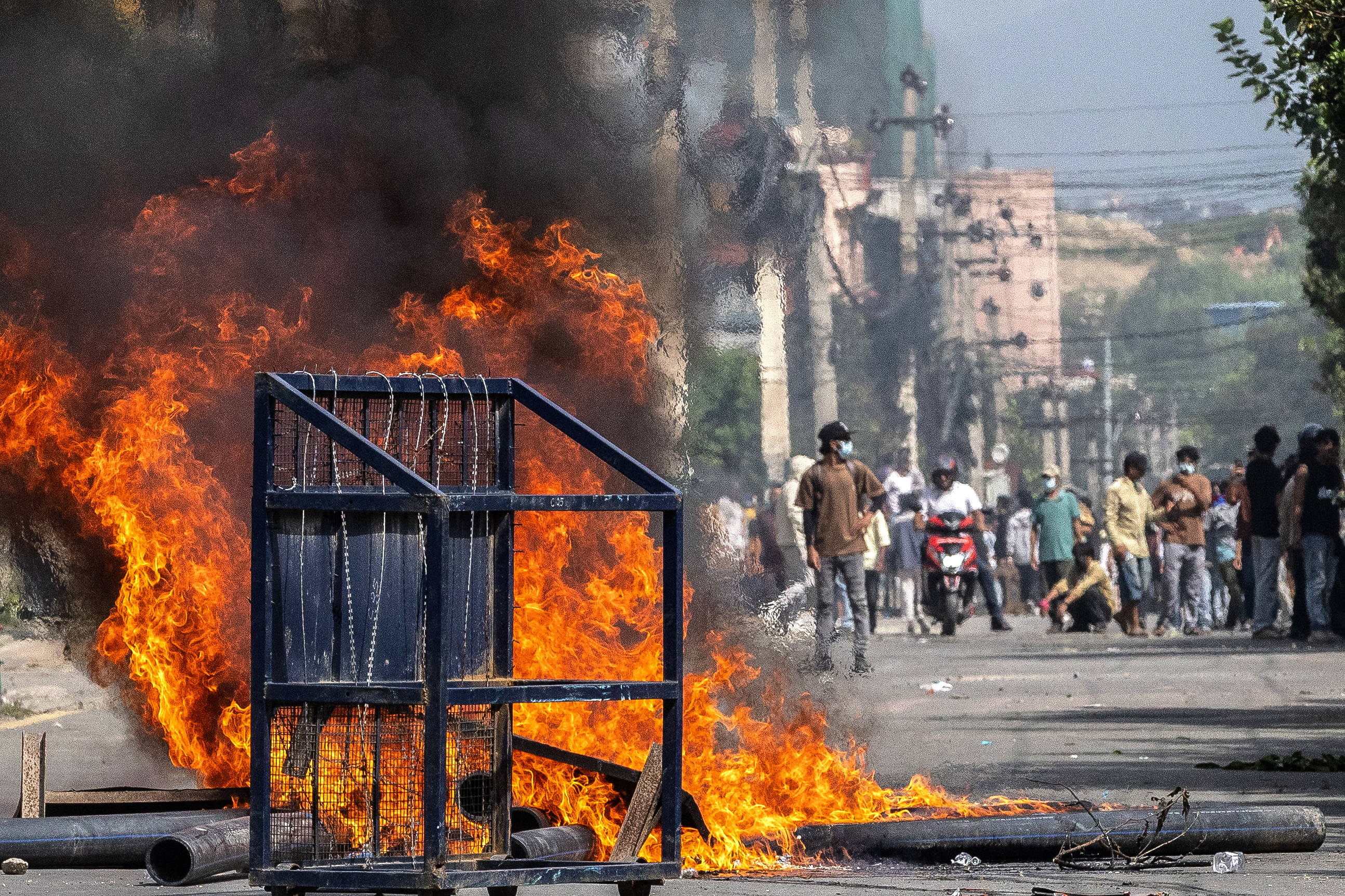 A police barricade is pictured in front of a fire set alight by demonstrators during a protest outside the Parliament in Kathmandu on September 8, 2025, against social media prohibitions and corruption by the government.