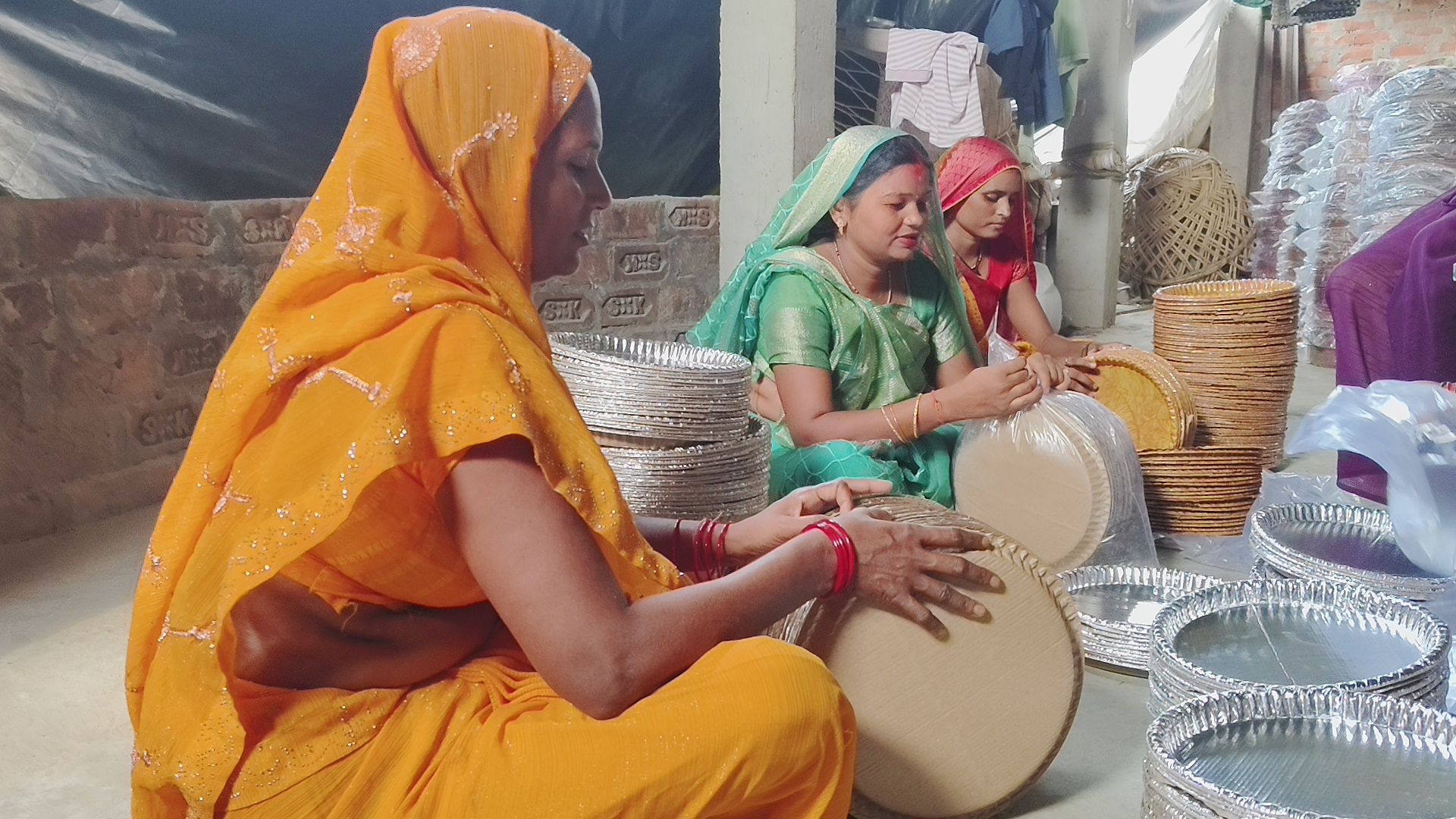 Seema helps fellow women in making Dona Pattal.