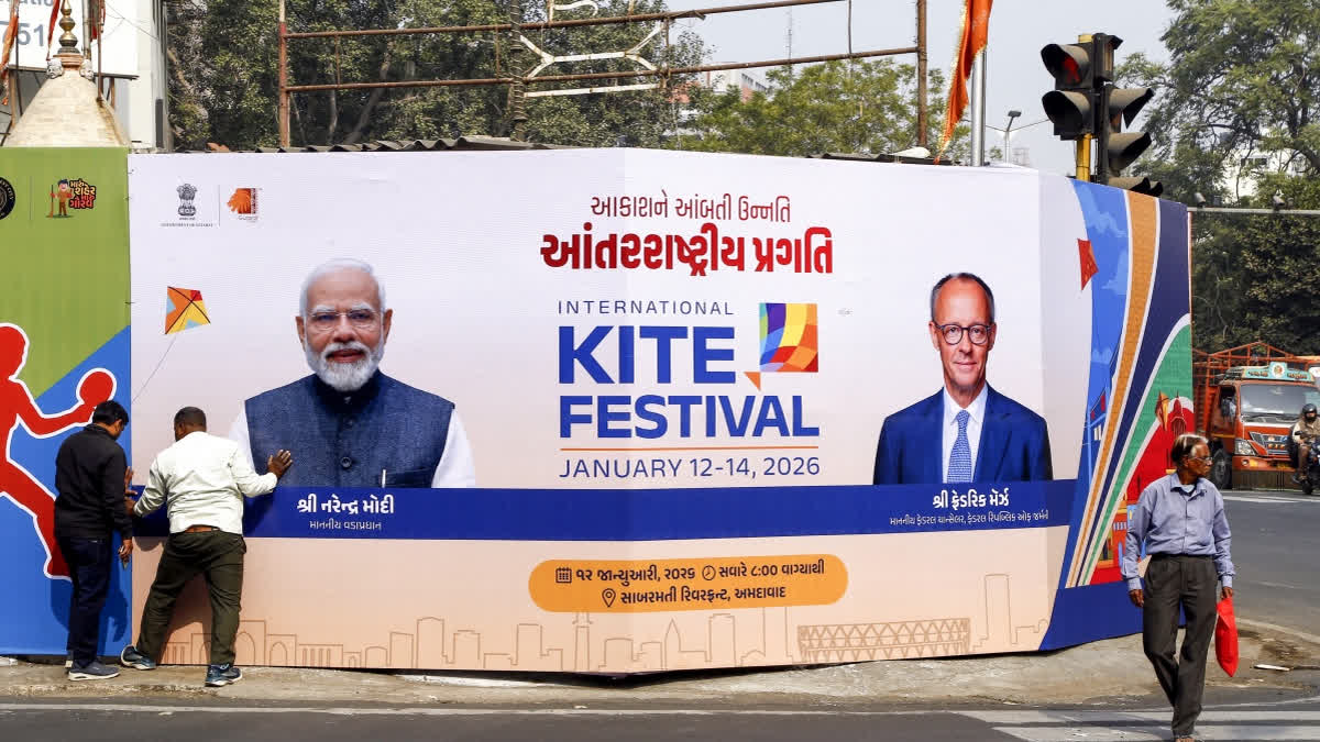 Workers arrange a welcome hoarding of Prime Minister Narendra Modi and Vice Chancellor of the Federal Republic of Germany Friedrich Merz ahead of their scheduled visit at International kite festival, in Ahmedabad.