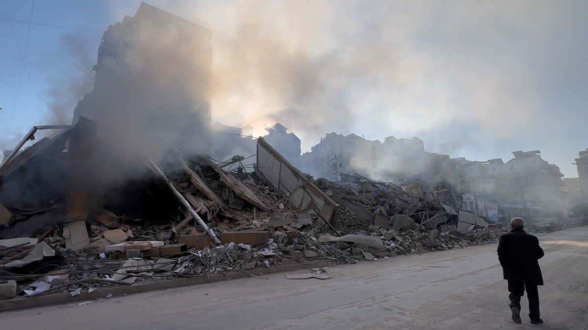 A man passes in front of a destroyed building that housed a branch of Al-Qard Al-Hassan, a non-bank financial institution run by Hezbollah, which was hit by an Israeli airstrike in Dahiyeh, Beirut's southern suburbs, Lebanon, Tuesday, March 10, 2026.