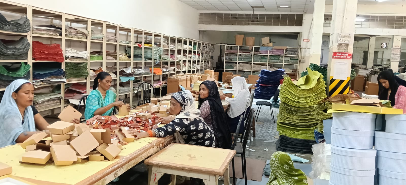 हस्तनिर्मित कागज से अलग-अलग कलाकृति तैयार करते हुए कारीगर