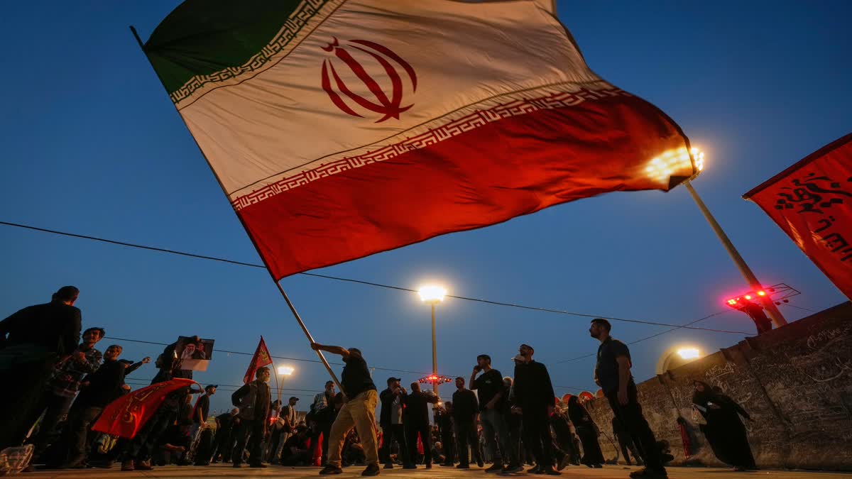 پانچ جولائی 2026 کو تہران میں امام خمینی مصلیٰ گرینڈ مسجد میں مقتول ایرانی سپریم لیڈر آیت اللہ علی خامنہ ای اور ان کے خاندان کے افراد کی آخری رسومات کے دوران ایک شخص ایرانی پرچم لہراتے ہوئے