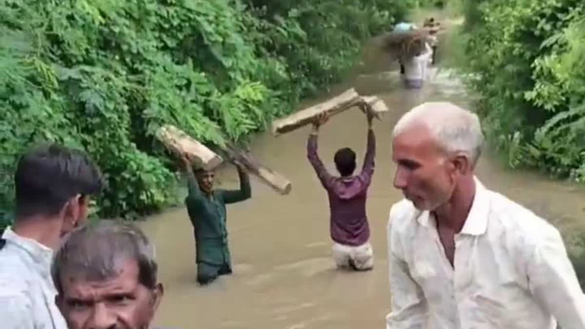Villagers in Kachnariya village of Ichhawar block forced to wade through waist high water to carry a body for last rites due to absence of a proper road.