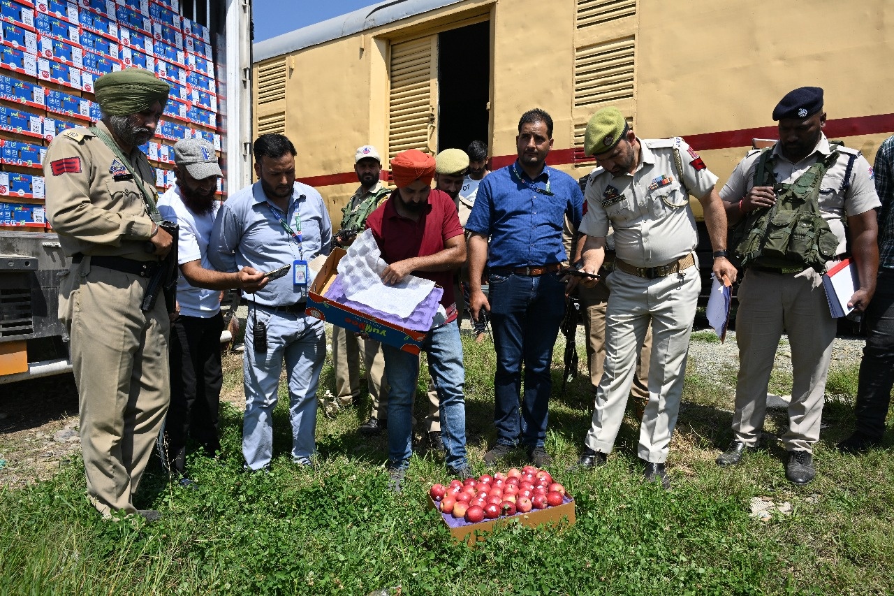 Police officials checking one of the apple boxes before it is loaded in the first parcel train from Kashmir to Delhi at Budgam station in J&K on Thursday, Sept 11 2025.