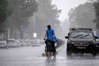 cyclist goes during rain in New Delhi.