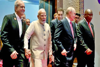 Prime Minister Narendra Modi holds Iranian President Masoud Pezeshkian's hand at the BRICS Business Forum 2026, in New Delhi on Friday. Russian President Vladimir Putin and South African President Cyril Ramaphosa are also seen in the photo.
