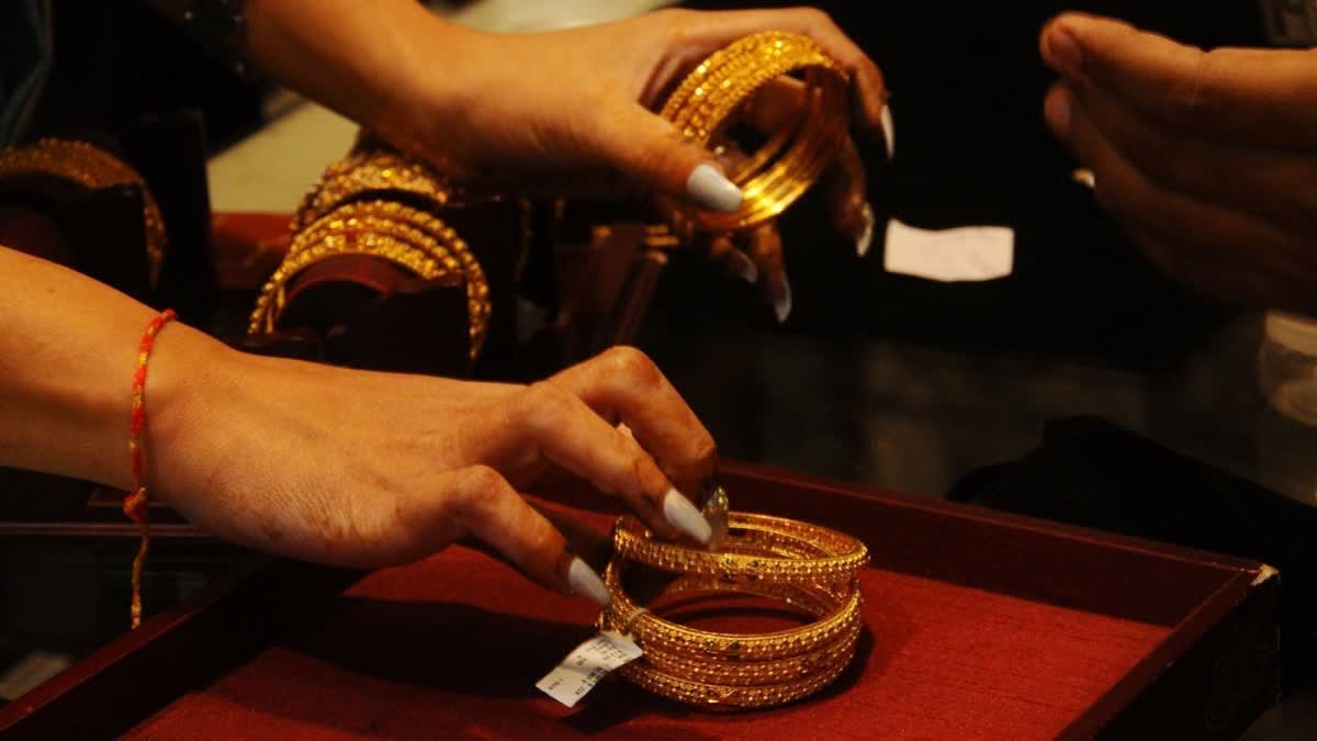 People shop for Gold ornaments at a jewellery store