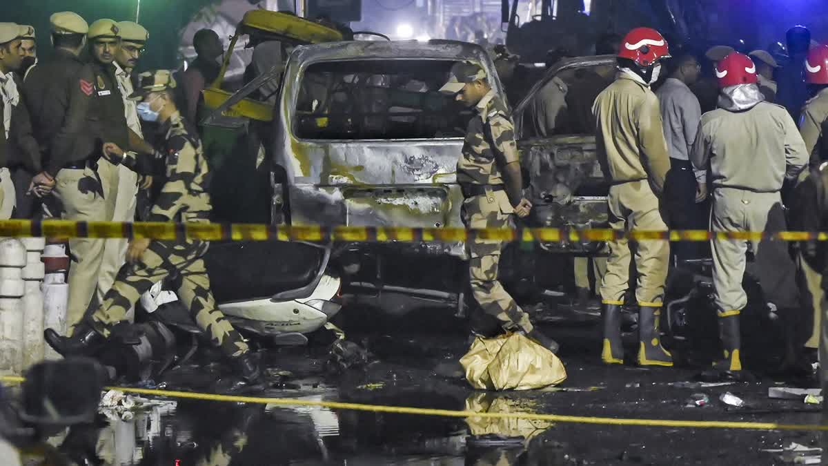 Investigators examine the spot where a car blast killed 12 people any many others injured near Red Fort in Delhi