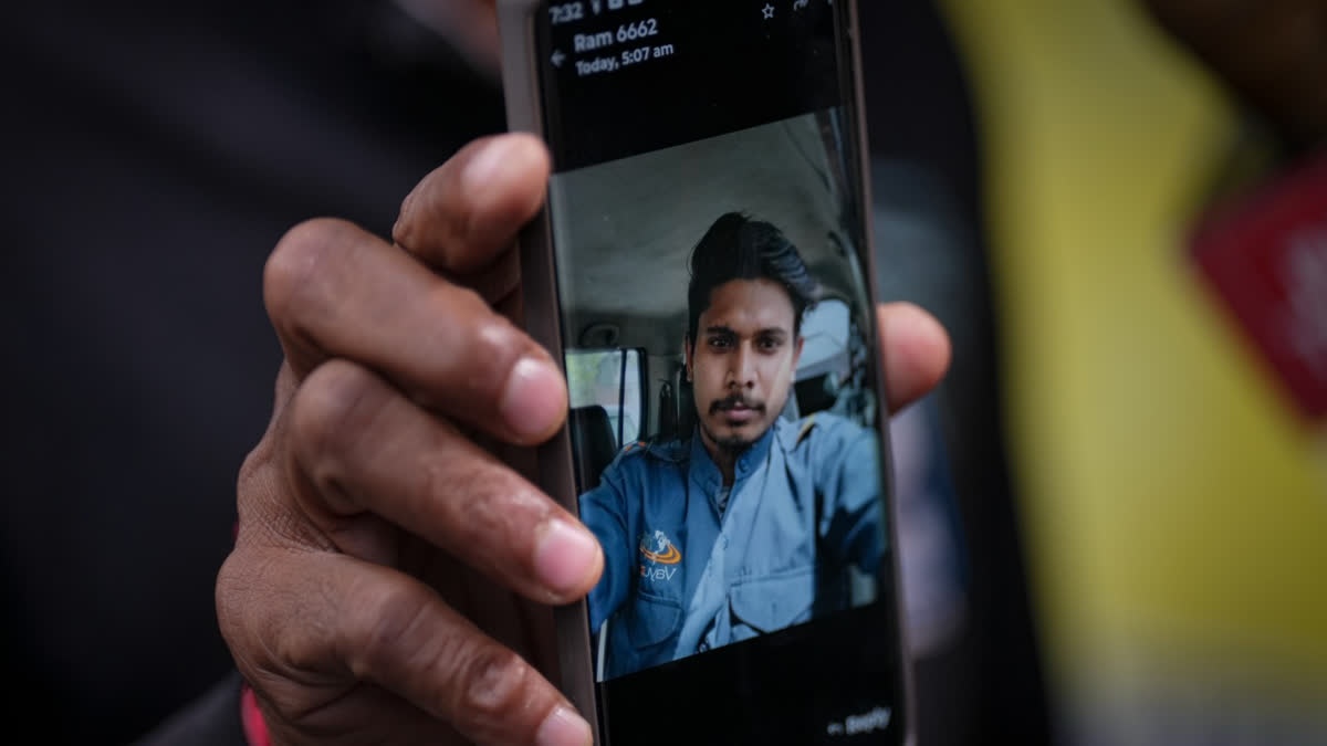 relative of Pankaj Saini shows a picture of the deceased