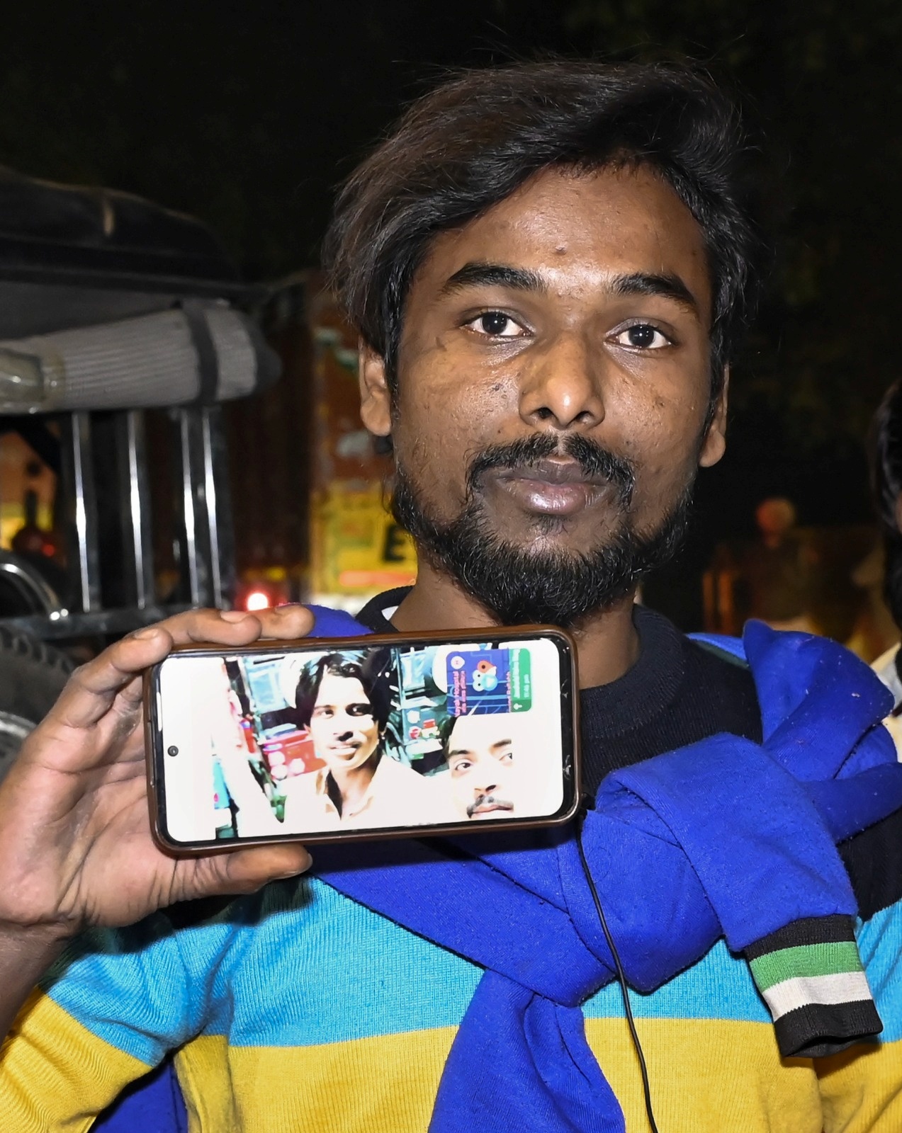 A relative of Jumman shows a picture of the deceased