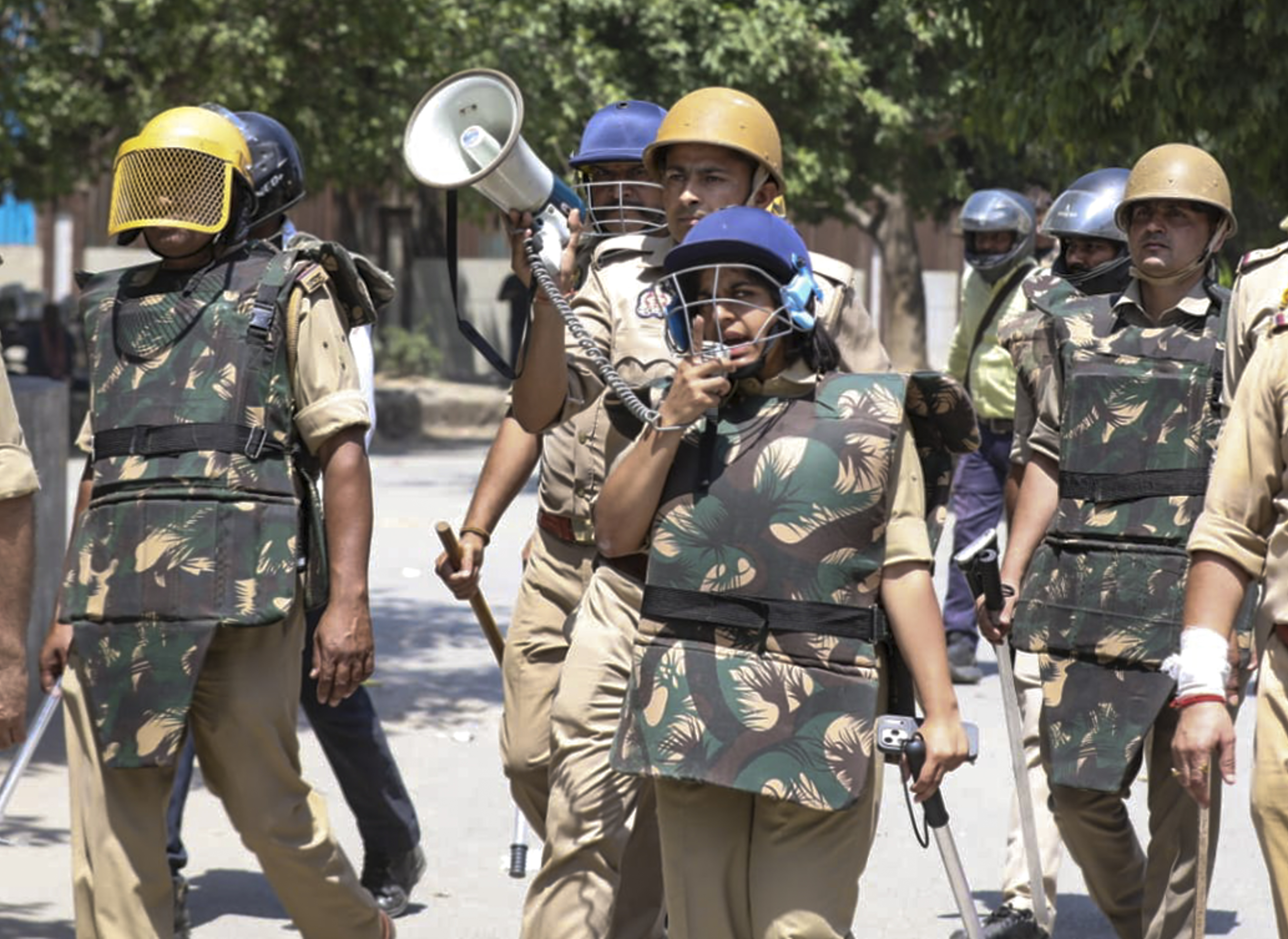Security personnel outside a factory as workers stage a protest demanding a hike in wages.