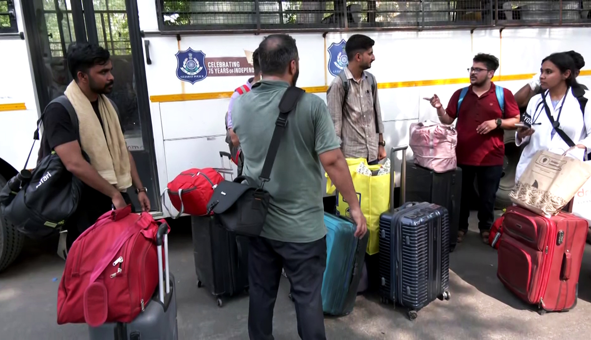 Students, professors, family members, and staff exit from BJ Medical College's doctors' hostel where the London-bound Air India flight crashed