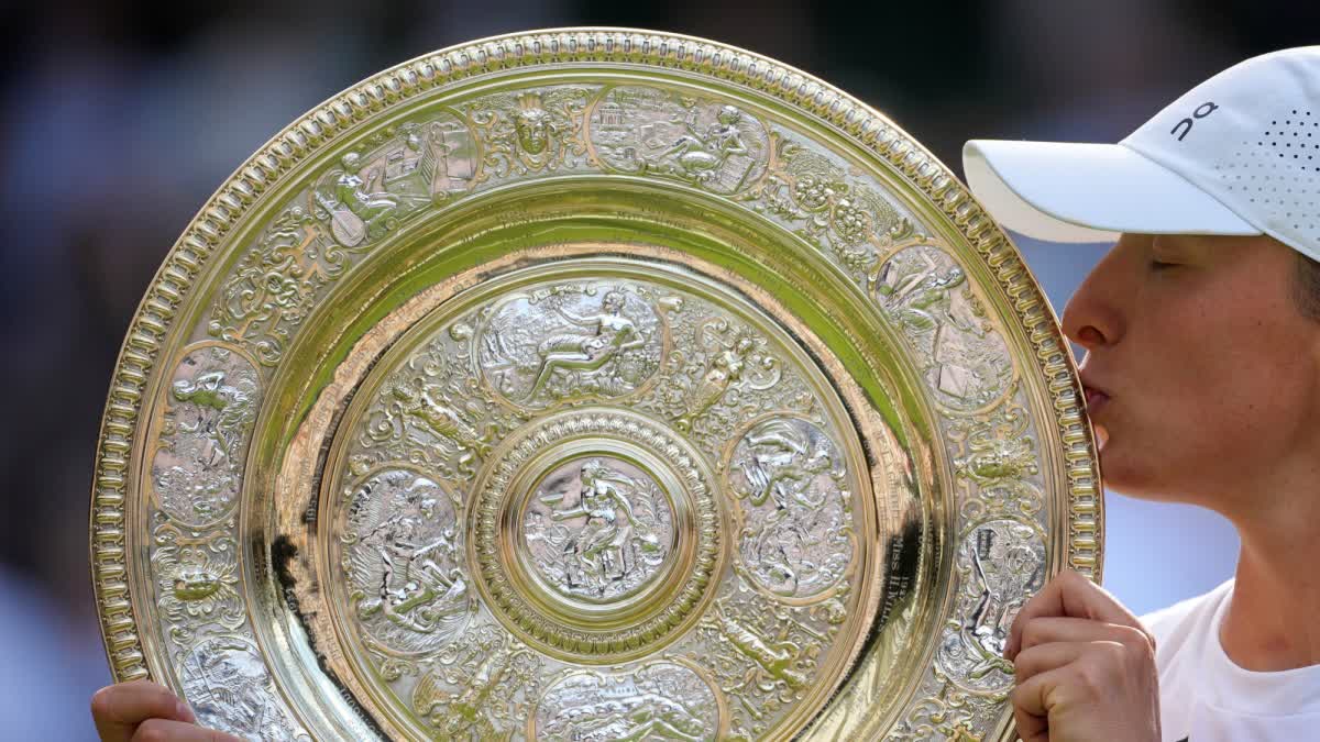 Poland's Iga Swiatek kisses the trophy after winning the Women's Singles of the Wimbledon Tennis Championships in London, Saturday, July 12, 2025.