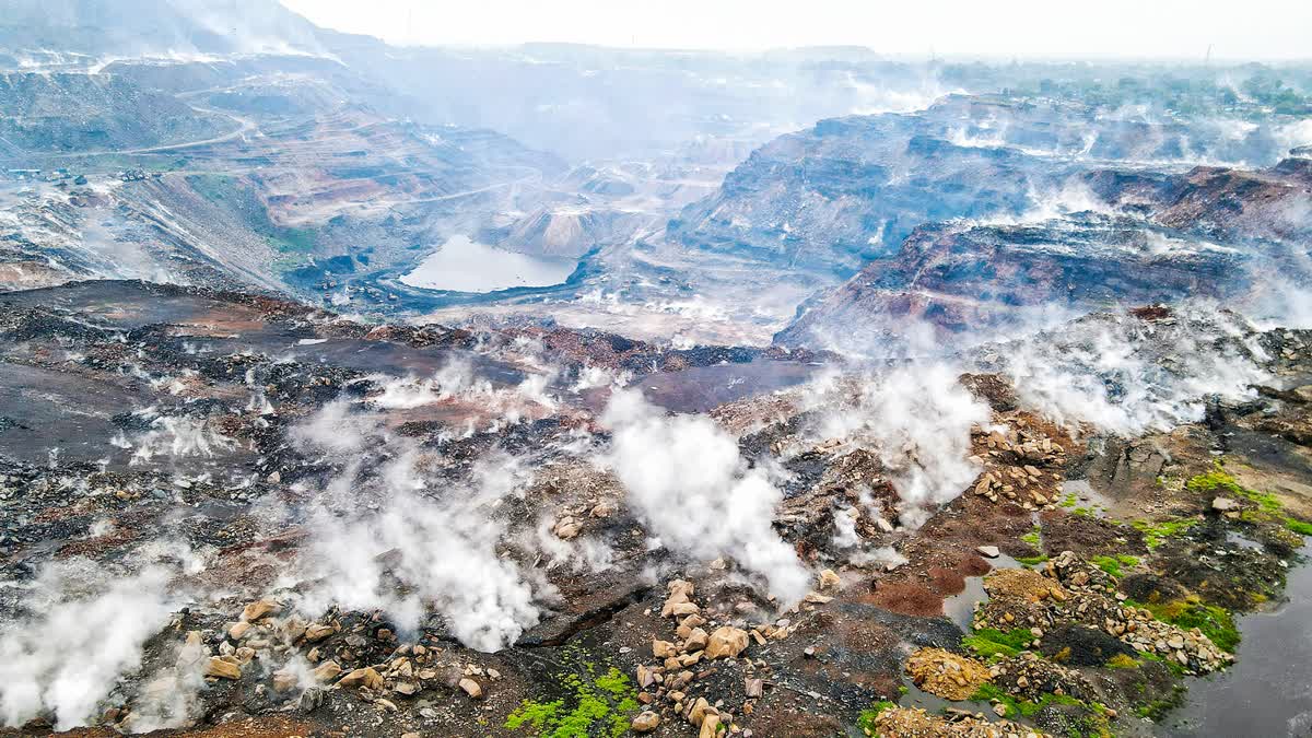 Thick and poisonous gas smoke billows from inside a coal mine in Dhanbad