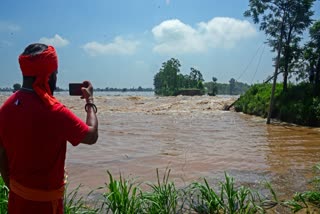 A man captures the rushing stream caused by the rise in the water level of a river following incessant rainfall at Nasirpur village in Jalandhar.