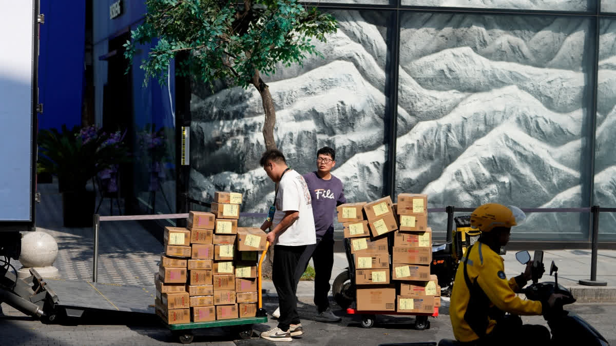 China's Exports To US Drop 27% In September; Rise In Global Shipments Hits 6-month High Workers deliver goods to a trendy shopping district during the National Day holidays in Beijing, China, Thursday, Oct. 2, 2025.