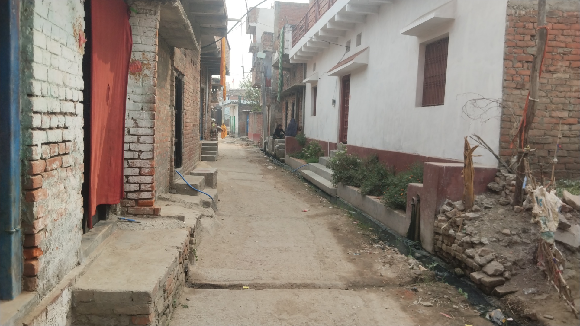 नल जल योजना की पाइप दिखाती ग्रामीण महिला