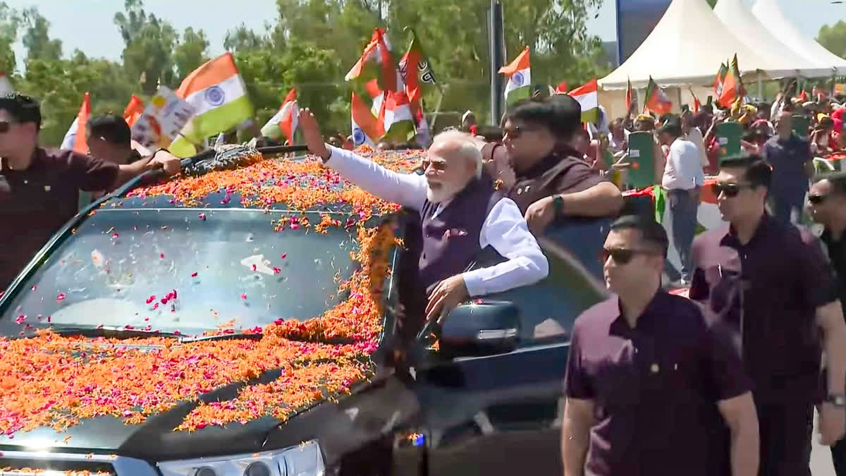 PM Modi greets supporters during a roadshow.