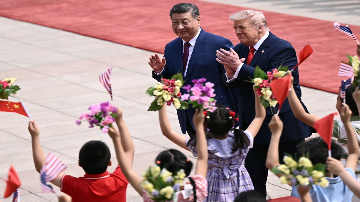 US President Donald Trump (R) and China's President Xi Jinping (L) greet children waving Chinese and US national flags and flowers during a welcome ceremony at the Great Hall of the People in Beijing