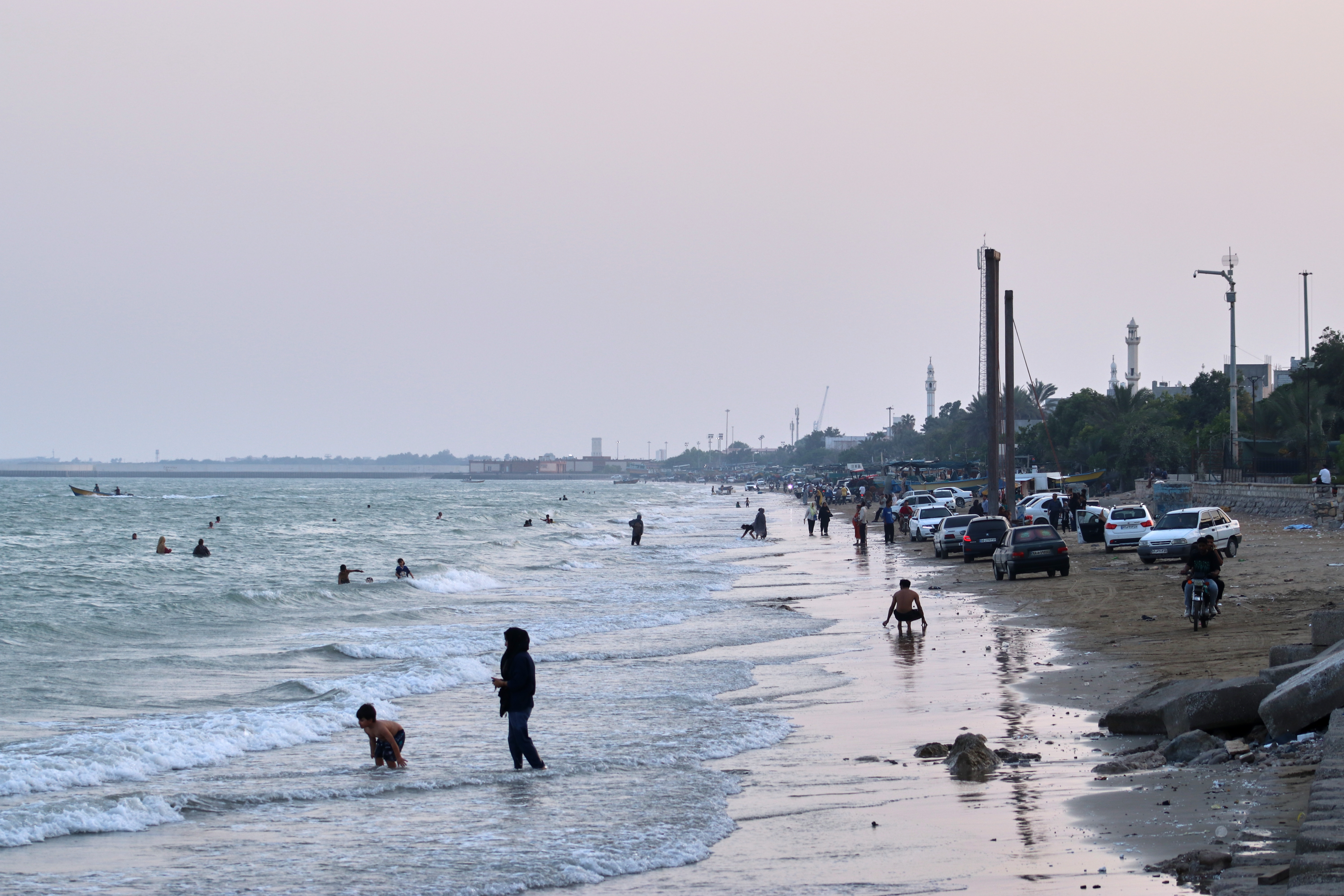 People swim and spend time along the shore of the Strait of Hormuz, off Bandar Abbas, Iran, Sunday, July 12, 2026. (