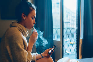 Young woman vaping at home
