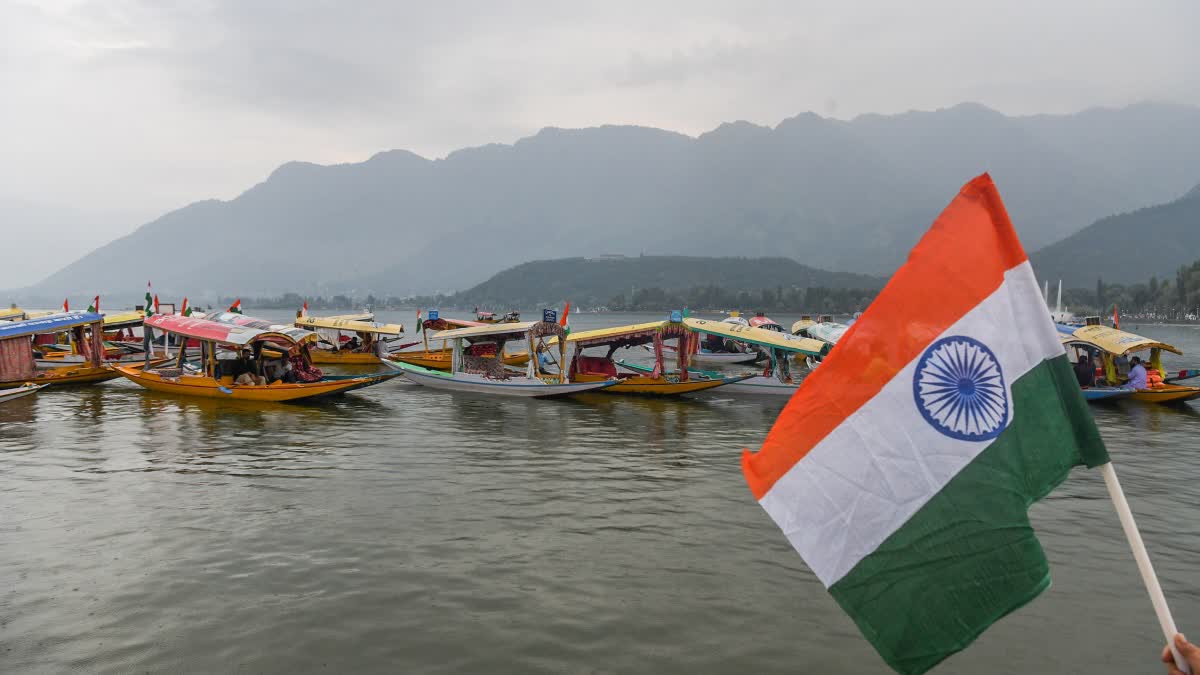 The national flag being waved near a line of shikara boats on the waters of Dal Lake during a Tiranga rally ahead of Independence Day,