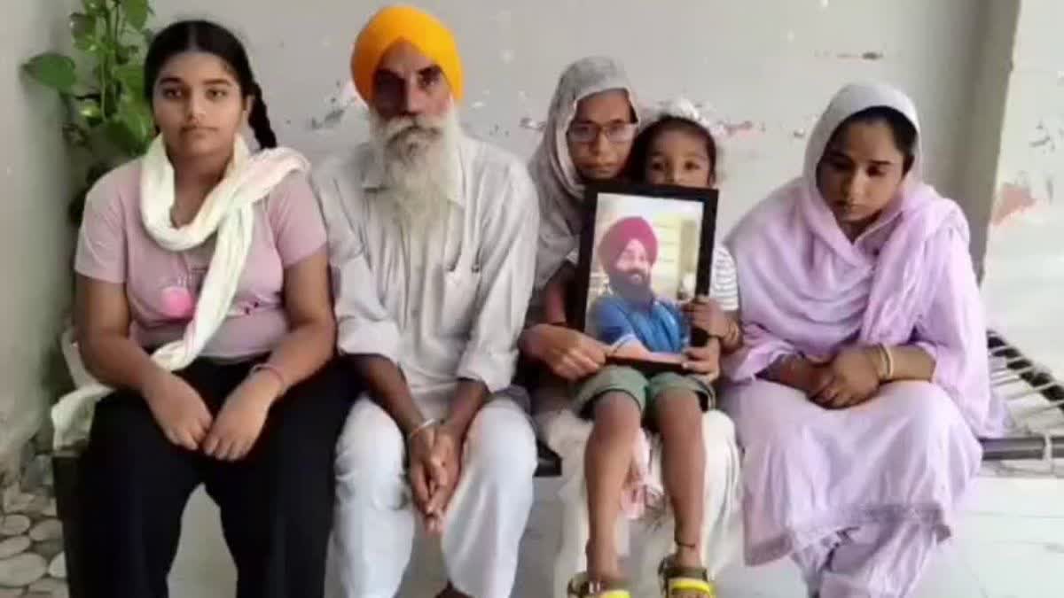 Baljinder Singh's family with his photo.