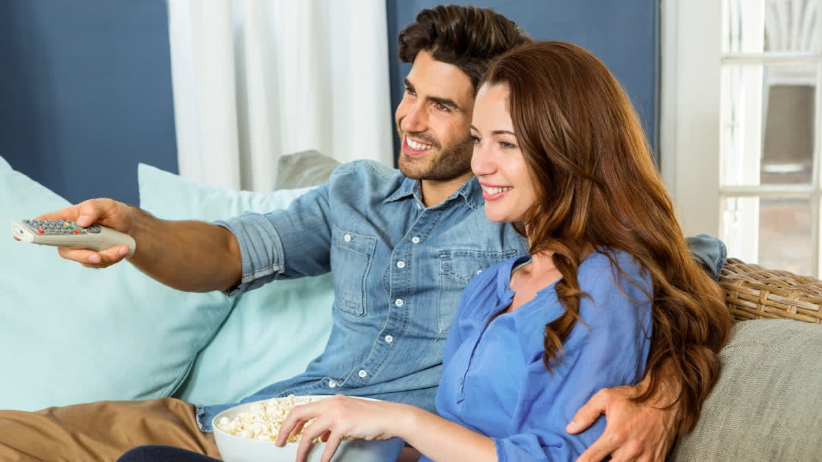 Couple watching television on a couch