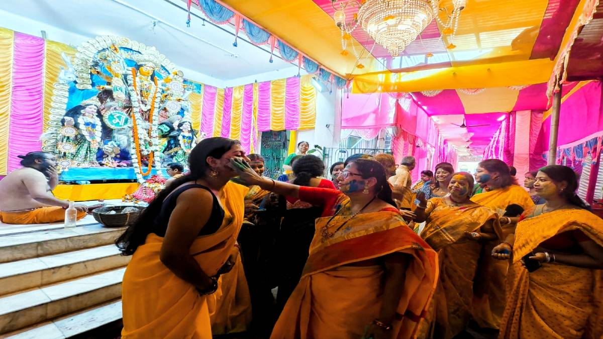 Women play Holi in front of goddess Durga in Serampore.