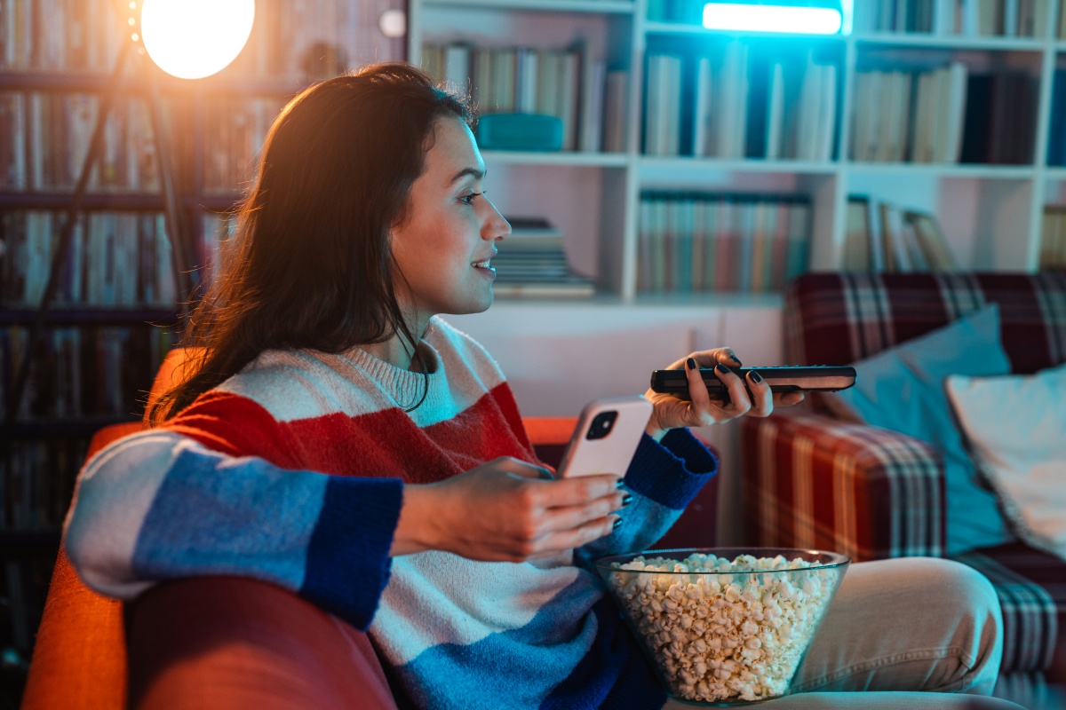 Woman watching television with a bowl of popcorn