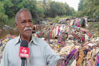 தாமிரபரணி ஆற்றில் குவியும் துணி கழிவுகளை நீக்கும் நபர்