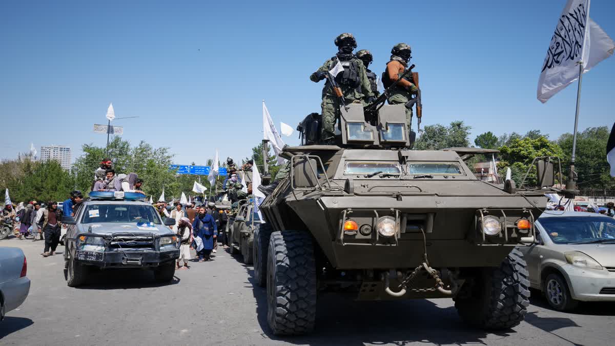 Armed Taliban ride atop an armoured vehicle during celebrations marking the fifth anniversary of the Taliban's return to power, in Kabul, Afghanistan, on August 15.