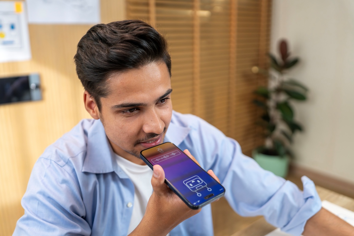 Indian man talking to AI assistant on his phone